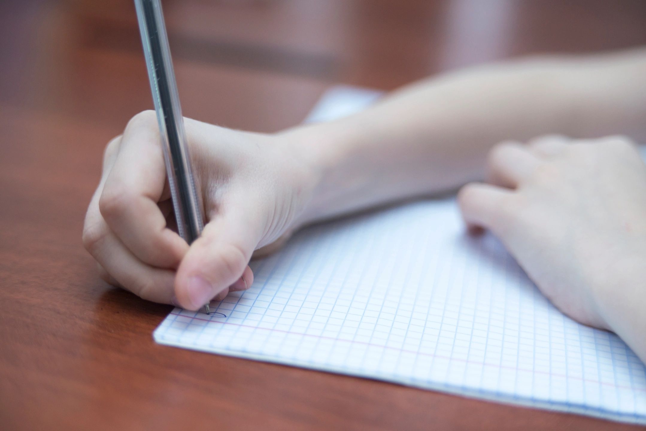 person holding a pen and about to write on a blank page